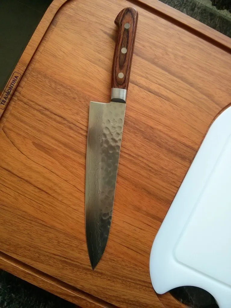 Japansk gyuto med trähandtag på en skärbräda