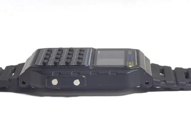 Casio CA-53W-1EZ – CA-53W-1EZ i sidoprofil med sidoknappar och bandinfästning synliga.