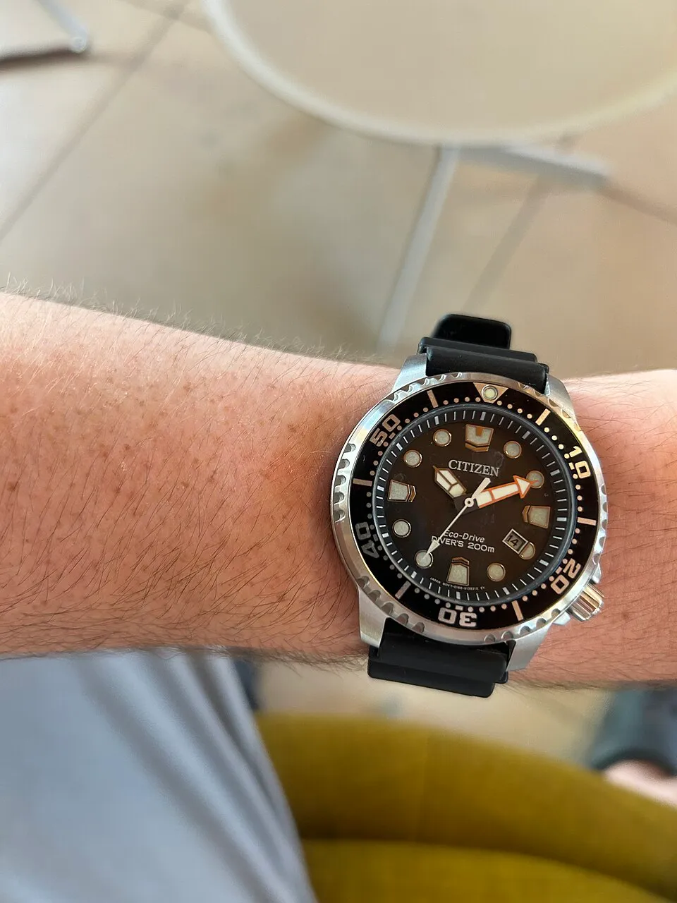Citizen BN0150-28E på handleden med svart band i varmt ljus.