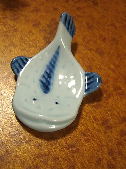 Eine weiß-blaue Stäbchenablage in Fischform.