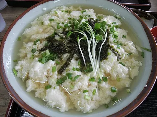 Ein Reisgericht mit Tofu in einer flach wirkenden, breiten Schale.