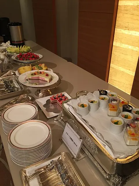 Dessertbuffet mit gestapelten Tellern und vielen kleinen Portionsgefäßen.