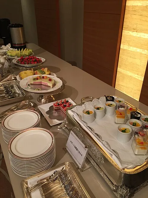 Dessertbuffet mit gestapelten Tellern und vielen kleinen Portionsgefäßen.