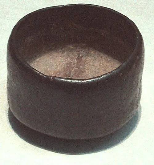 Eine schwarze Raku-Teeschale mit unregelmäßig wirkender Oberfläche.