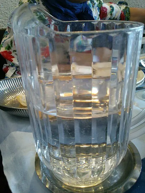 Wasser in einer transparenten Karaffe mit Henkel in einem Restaurant.