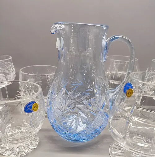 Glaskrug mit passenden Gläsern in einer Verkaufsvitrine.
