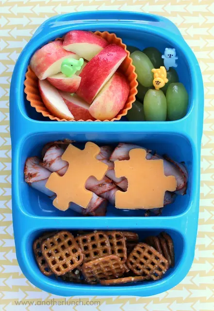 Eine längliche blaue Lunchbox mit drei hintereinander angeordneten Fächern.