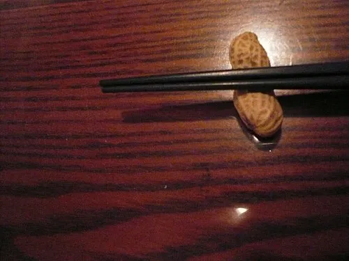 Schwarze Essstäbchen auf einer kleinen erdnussförmigen Ablage in Tokio.