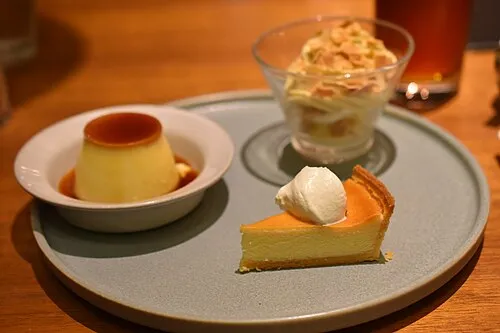 Dessertteller mit Pudding, Kuchen und einem kleinen Glasgefäß.