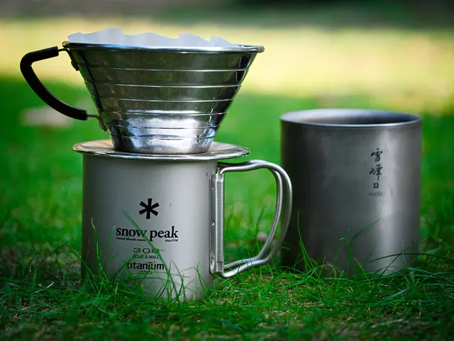 Metall-Kaffeefilter auf einem Snow-Peak-Becher neben einem zweiten Titanbecher