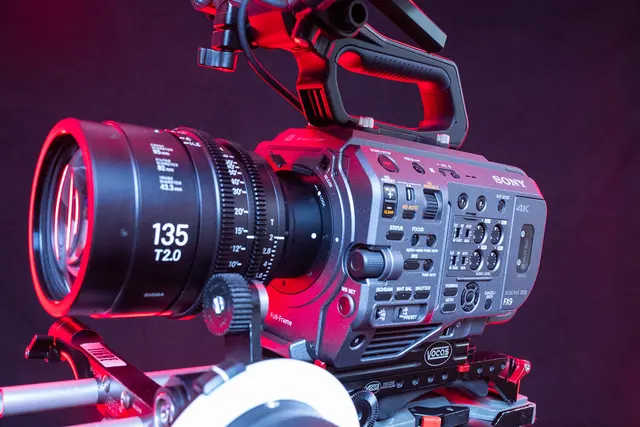 Sony-Filmkamera mit Sigma-Cineobjektiv unter farbigem Studiolicht