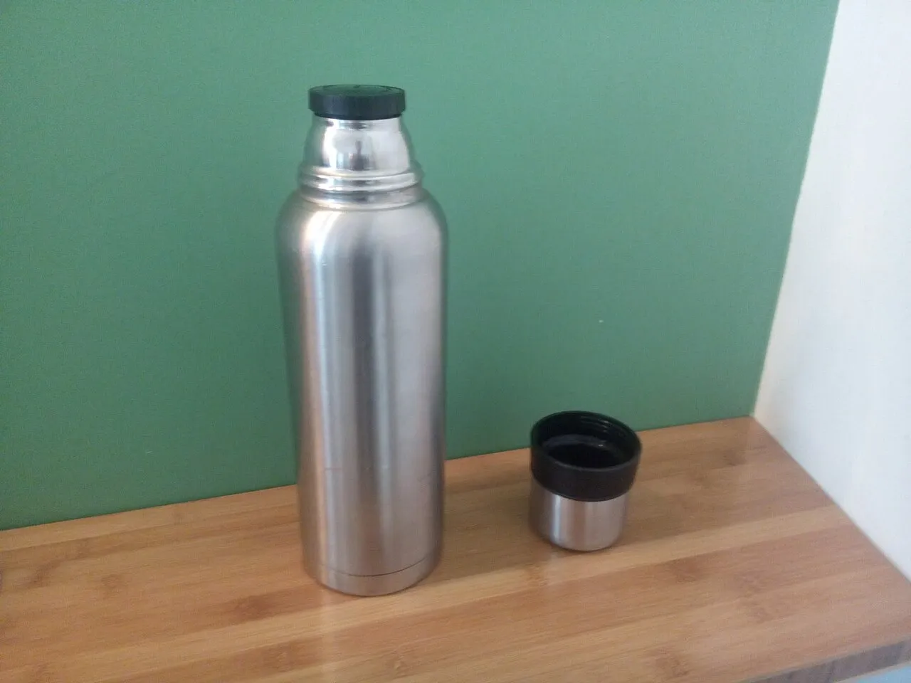Geöffnete Metall-Isolierflasche mit abgenommenem Becherdeckel