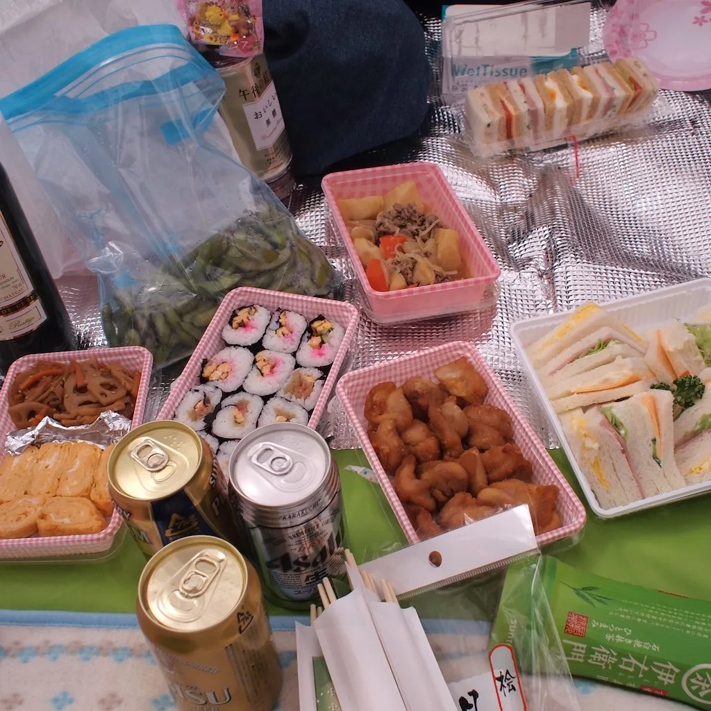 Verschiedene Speisen in Lunchboxen mit Getränken bei einem japanischen Picknick