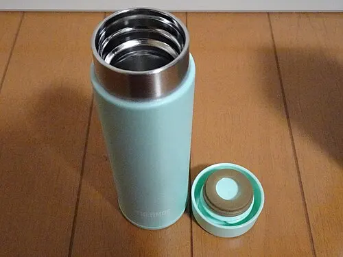 Geöffnete mintfarbene Thermos-Flasche mit abgenommenem Schraubdeckel
