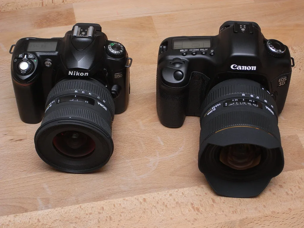 Nikon- und Canon-Kamera mit unterschiedlichen Sigma-Zoomobjektiven nebeneinander
