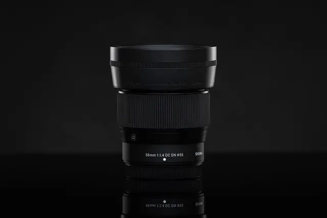 Sigma 56mm F1.4 DC DN Contemporary auf einer spiegelnden dunklen Fläche