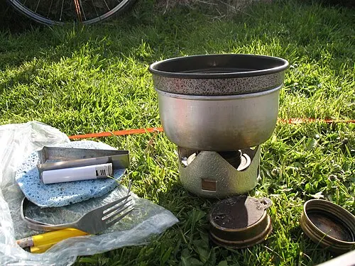 Mini-Trangia-Kochset mit Topf auf dem Brenner und abgelegtem Zubehör