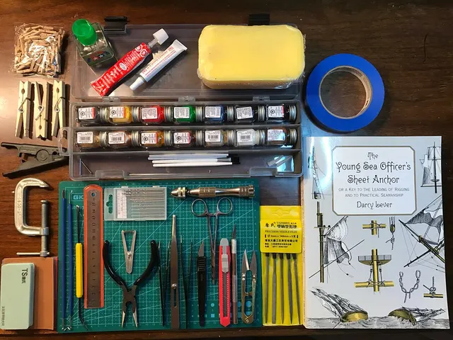 Zusammengelegte Modellbauwerkzeuge mit Schneidmatte, Messern, Zangen, Bohrern und Verbrauchsmaterial.