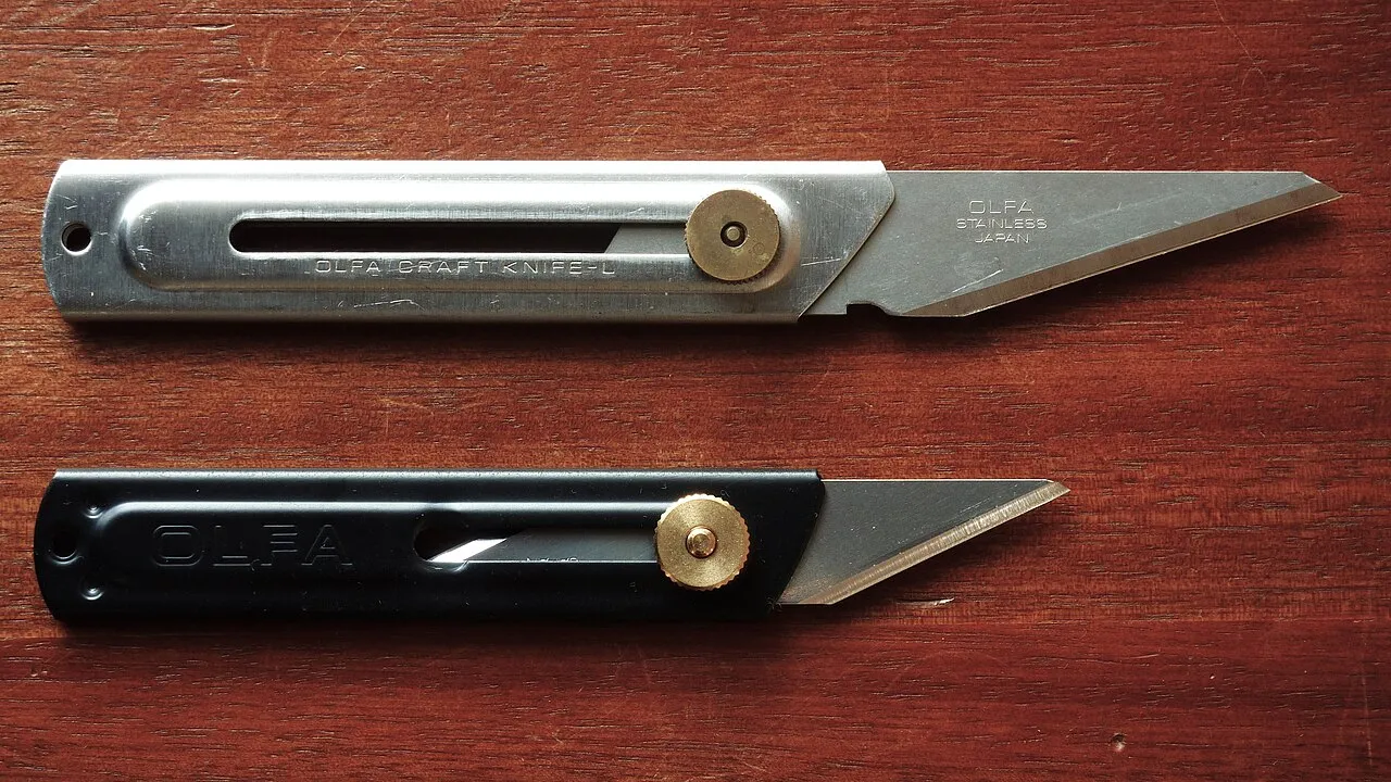 Zwei OLFA-Bastelmesser mit flachem Metallgriff und feststellbarer Klinge.