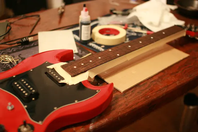 Maskierband schützt Bereiche einer Gitarre bei der Bearbeitung. Kontextfoto zur Führung an geraden und gekrümmten Konturen; kein Vergleich konkreter Modellbaubänder.