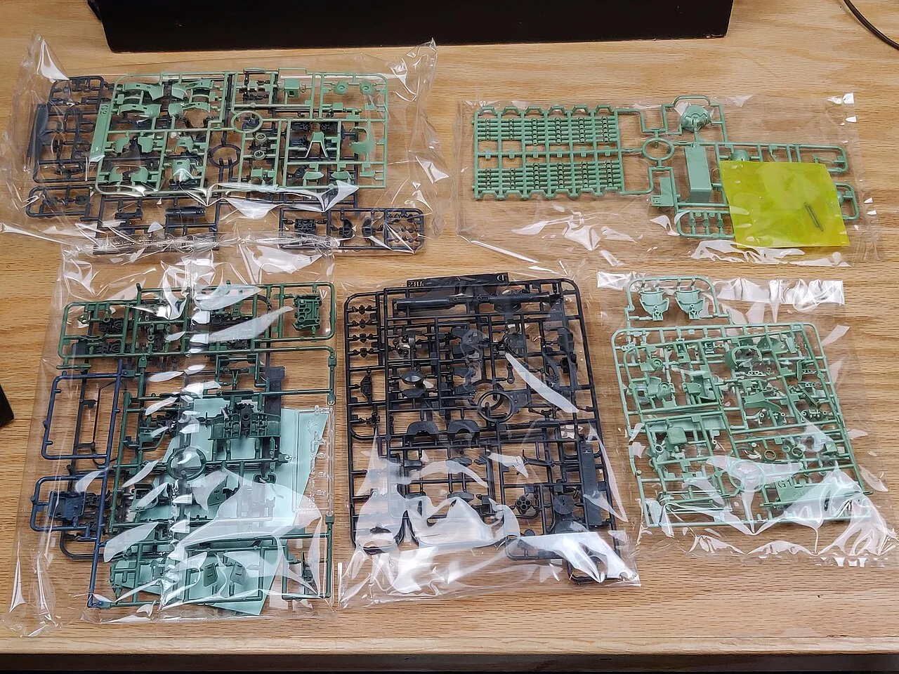 Ausgelegte Gussrahmen eines Bandai-Gunpla-Bausatzes veranschaulichen die Vorbereitung eines Modellbauprojekts