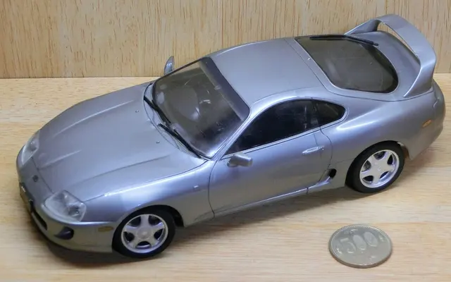 Gebautes älteres Tamiya-Toyota-Supra-Modell im Maßstab 1:24 neben einer Münze.