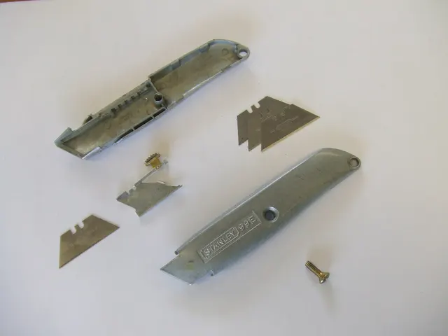 Zerlegtes Universalmesser mit Trapezklingen. Das andere Klingensystem veranschaulicht die modellabhängige Passform; diese Klingen sind weder OLFA KB-5 noch Tamiya 74075.