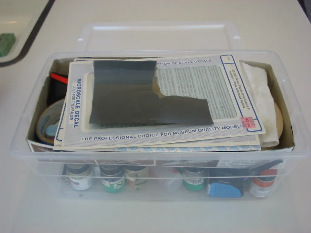 Transportabler Modellbauvorrat mit Werkzeugen, Farben, Schleifmitteln und Unterlage.