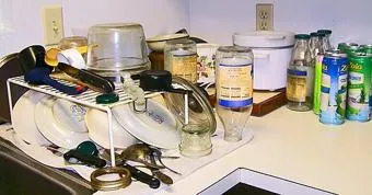 Topfdeckel und anderes gespültes Kochgeschirr auf einem Abtropfgestell.