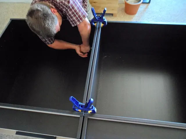 Zwingen halten Teile eines Möbelkorpus an der Kante zusammen, während eine Verbindung verschraubt wird. Kontextfoto für Klemmpunkte und benötigten Freiraum; kein Untertisch-Organizer.