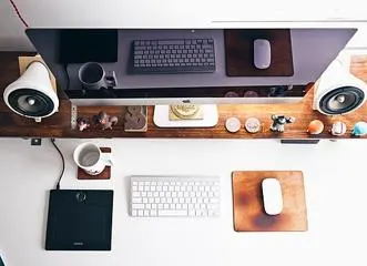 Monitor und Lautsprecher auf einer erhöhten Holzablage.