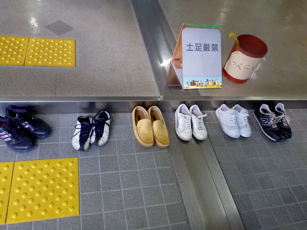Paarweise aufgestellte Schuhe in einem japanischen Eingangsbereich. Kontextfoto für einen festen Platz im täglichen Ablauf.